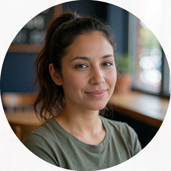 Smiling Latina woman with a high ponytail in a coffee shop, avatar for a sample first-message chat opener